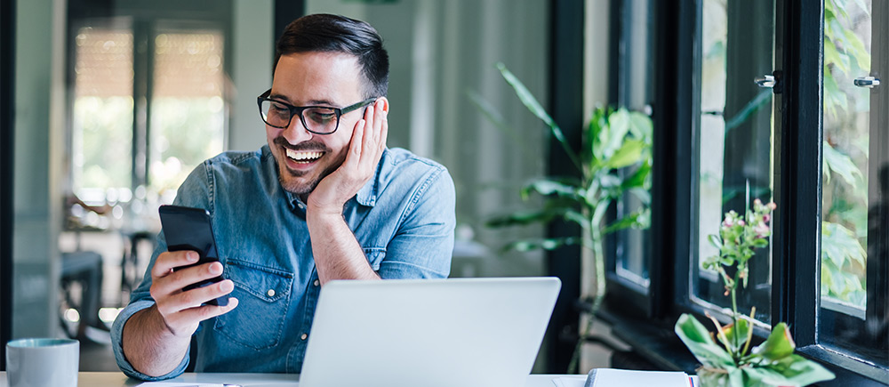 Happy business man checking phone