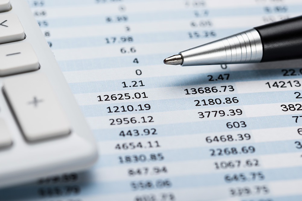 Close up of pen and calculator with financial spreadsheet